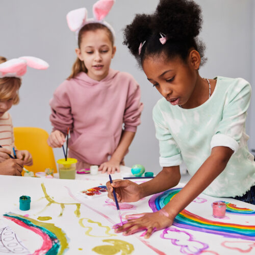 Diverse group of kids at art and craft table on easter party for children