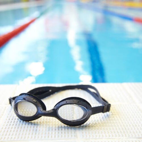 Image of swimming pool and goggles. Nobody